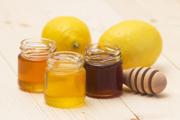 three jars of honey and fresh lemons