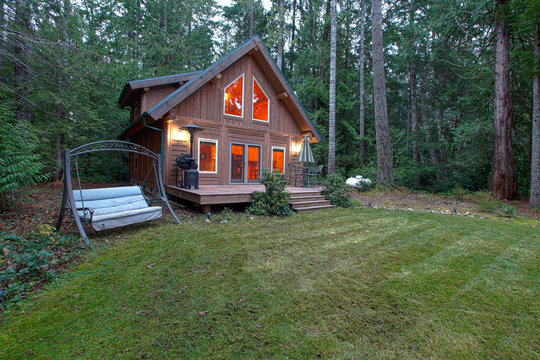 Cabin with back porch in the forest during evening