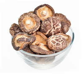 Dried field mushrooms in a glass bowl isolated on white