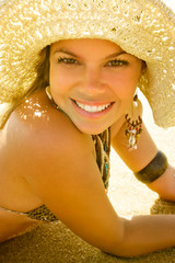 blond stunning bikini model smiles under hat golden light