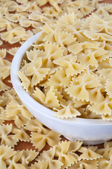 Raw farfalle pasta in white bowl