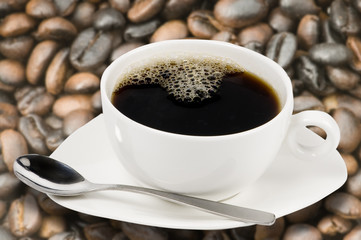Taza de café blanca con granos de café de fondo