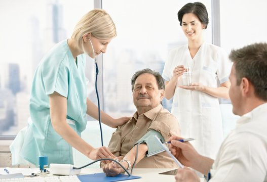 Nurse examining blood pressure for patient