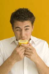 Mann beisst in Zitrone
