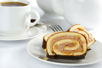 Slices of chocolate roll on a plate and cup of tea