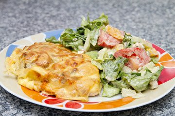 chicken breast baked under cheese with salad