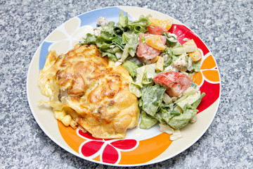 chicken breast baked under cheese with salad