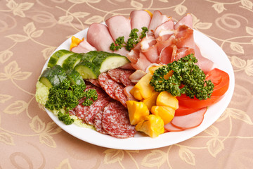 Meat and sausages with parsley and vegetables on white plate