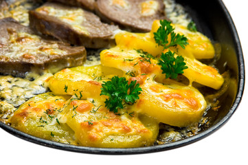 Meat and potatoes fried in a pan