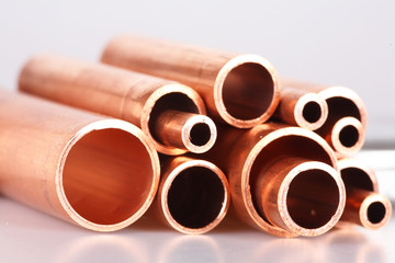 Set of copper pipes of different diameter lying in one heap