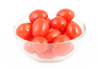 Ripe red tomatoes in a glass bowl on a white background