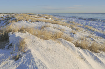 Shifting sand dunes covered with snow