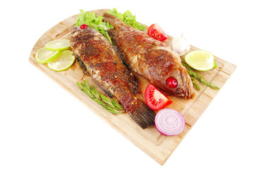 roasted sea fish on wood with tomatoes