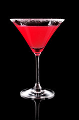 Martini glass with red coctail on black background