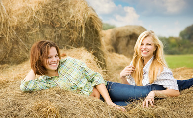 Naklejka na ściany i meble girls in checked shirts on hay