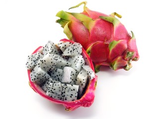 Diced dragon fruit pieces in the shell next to a whole fruit