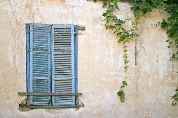 Fototapeta na wymiar Old blue window on old wall