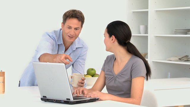 Woman working on the laptop with her husband