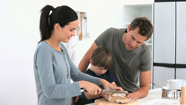 Adorable family cutting bread
