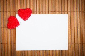 two red hearts with paper card