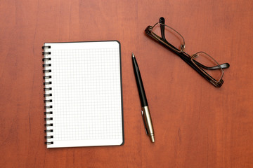 glasses, notepad with pen