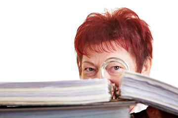 Seniorin versteckt sich hinter Aktenordner