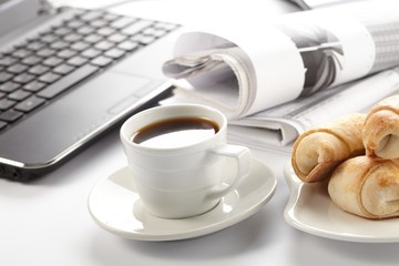 Cup of fragrant coffee on a morning paper business news