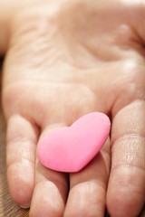 Woman holding pink heart in the hand