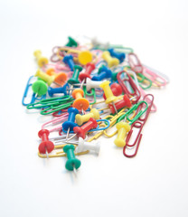Group of paper clips and pins on white