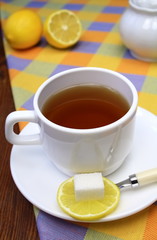 Cup of tea with a lemon and sugar.
