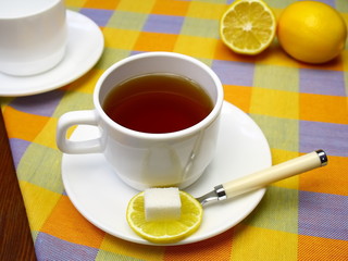 Cup of tea with a lemon and sugar.