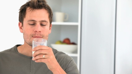 Handsome man drinking a glass of milk