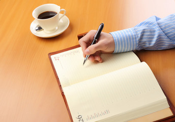 Fototapeta na wymiar Businessman writing a note at his workplace.