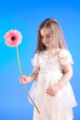 Obraz na płótnie Canvas Little Girl with long hair holding real Flower