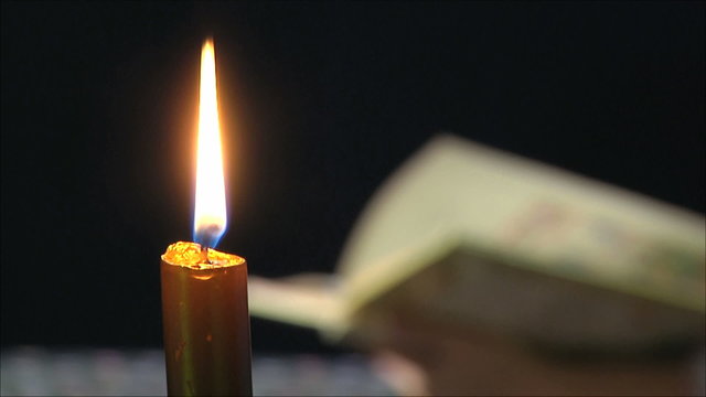 свеча и книгой на черном фоне