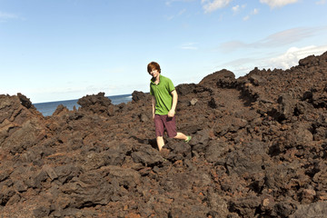 boy walking in volcanic area