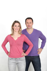Couple standing on white background with hands on hips