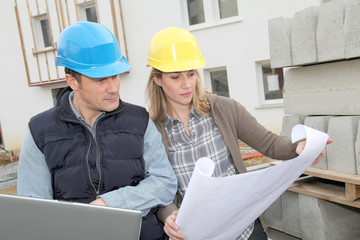 Architect and engineer looking at plan on construction site