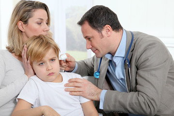 Doctor cheking little boy's ear infection