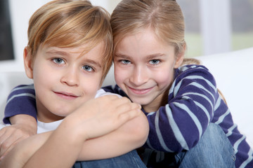 Portrait of young children sitting in sofa at home