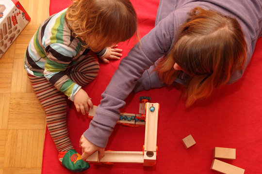 Mutter und Kind beim Spielen mit einer Kugelbahn