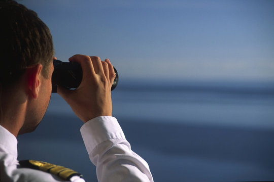 Offizier schaut mit dem Fernglas &uuml;bers Meer