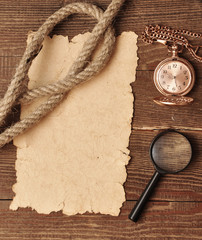 old paper with pocket watch and magnifying glass