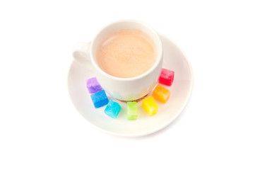 Multicolored slabs of shugar and cup of coffee