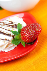 lemon tea, cake and strawberries lying on the orange fabric