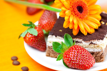 gerbera,  cake and strawberries lying on the orange fabric