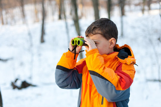 Child with binoculars in the forest