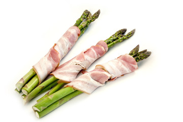 Asparagus wrapped in bacon on a white background.