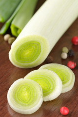 Fresh porrum with color pepper on a wooden table