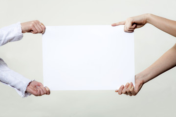 Four hands holding blank advertisement paper